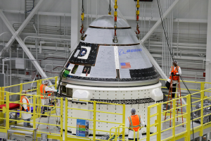 Oct. 16, 2019 - Boeing’s CST-100 Starliner spacecraft's crew module is lifted onto its service module inside the Commercial Crew & Cargo Processing Facility, Kennedy Space Center, before its Orbital Flight Test. Credits: Boeing